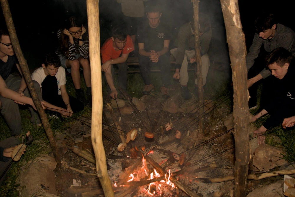 Účastníci sústredenia KSP vonku opekajú